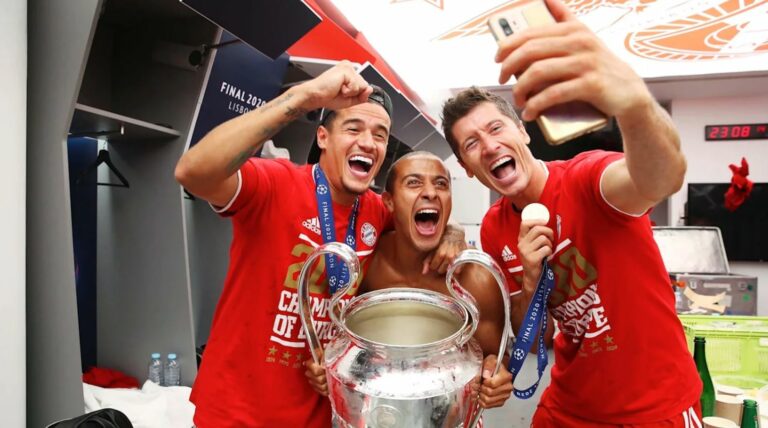 LISBON, PORTUGAL - AUGUST 23: (L-R) Philippe Coutinho, Thiago and Robert Lewandowski of FC Bayern Muenchen pose with the trophy in the dressing room following their team's victory in the UEFA Champions League Final match against Paris Saint-Germain at Estadio do Sport Lisboa e Benfica on August 23, 2020 in Lisbon, Portugal. PHOTO BY M. DONATO/FC BAYERN VIA GETTY IMAGES