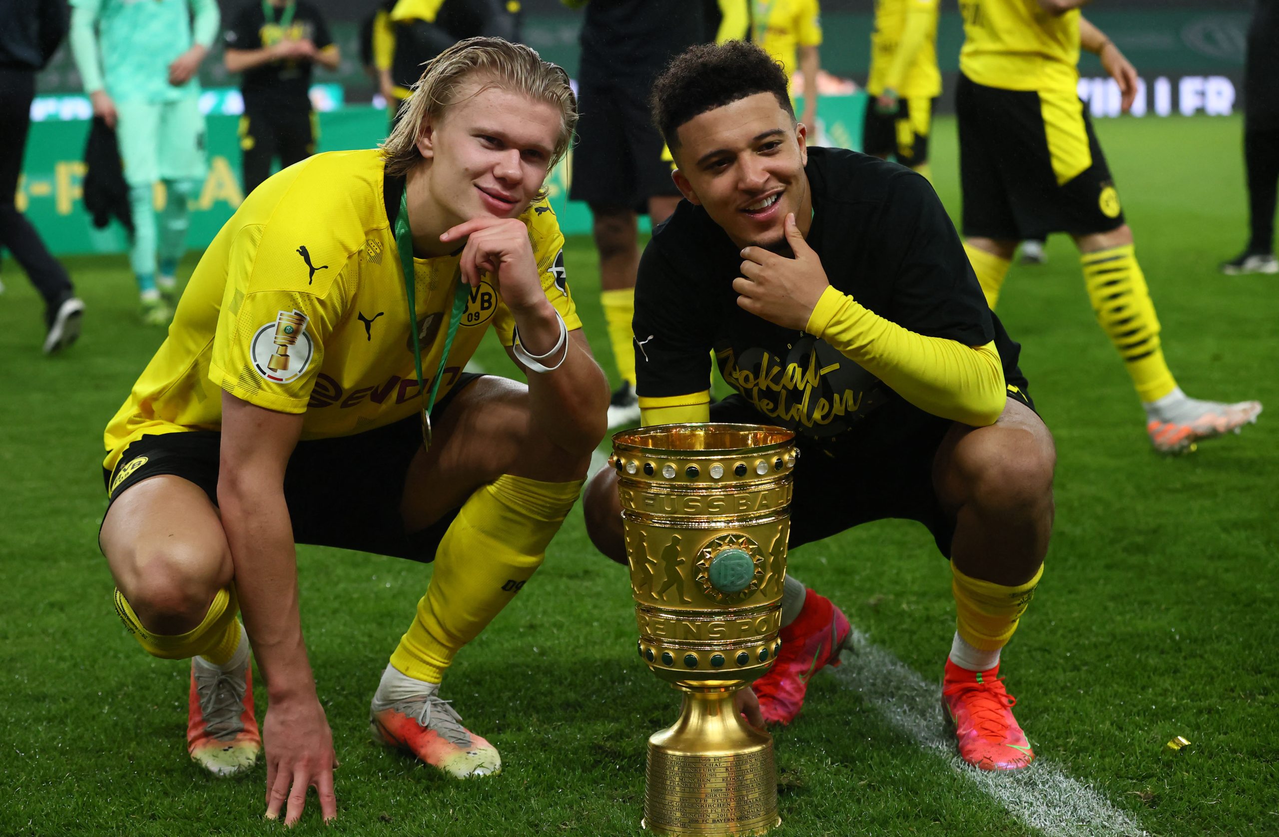 Dortmund's Norwegian forward Erling Braut Haaland (L) and Dortmund's English midfielder Jadon Sancho pose with the trophy after winning the German Cup (DFB Pokal) final