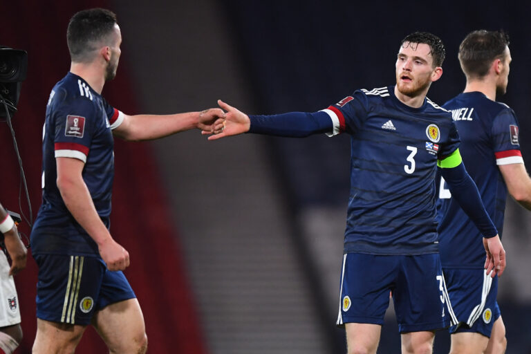Scotland's defender Andrew Robertson (R) congratulates Scotland's midfielder John McGinn (L) on the pitch after the FIFA World Cup Qatar 2022 qualification football match between Scotland and Austria at Hampden Park in Glasgow on March 25, 2021. - The game finished 2-2.